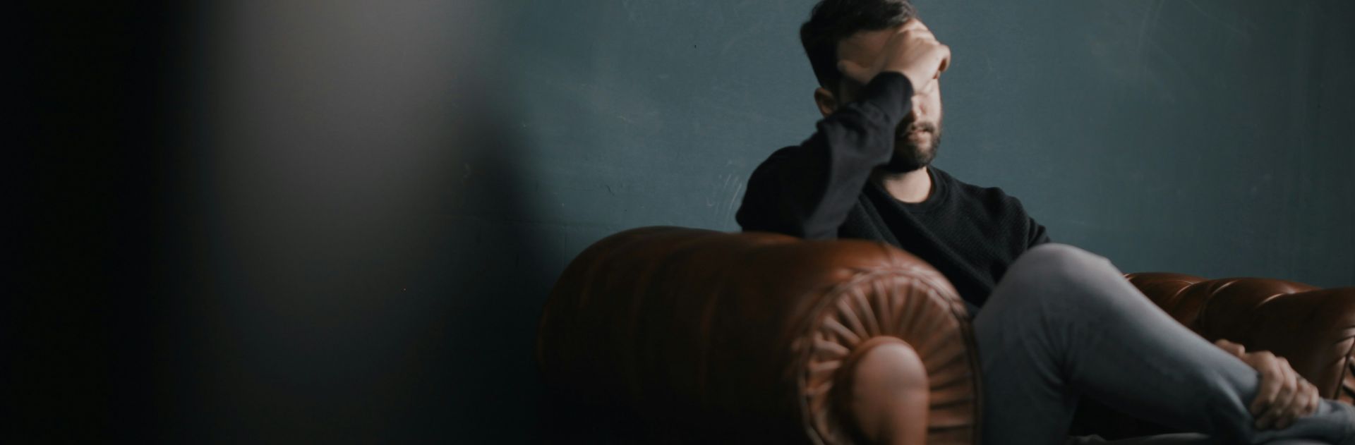 Man on a couch suffering from mental problems